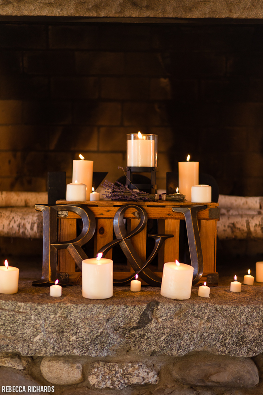 Unique ceremony details. Wooden initials, candles, fireplace. Cabin wedding. Maine.